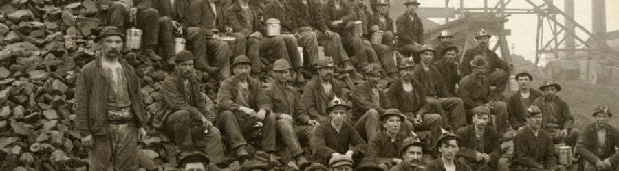 Miners pose with lunch pails in hand on a mine rock pile outside of the Tamarack mineshaft.