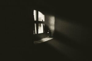 Image of a dark room with light streaming through a window.